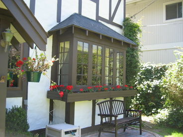 Beautiful bay windows with Red Geraniums during summer and bench to watch croquet players in front lawn.