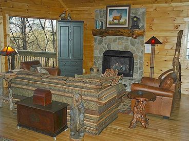 Living Room with gas log fireplace, entire glass front looking at the layered mountain view