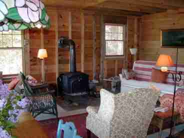 living room with wood stove, cozy chairs and couch
