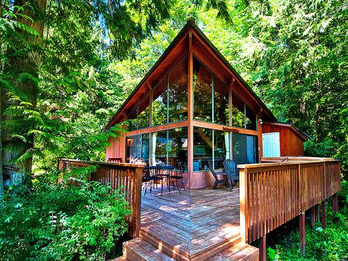 Rustic River Paradise is nestled amongst trees with a stunning view of the river.
