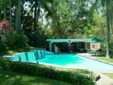 40 ft heated pool and party caba�a, surrounded by tropical trees.