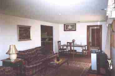 Living room, dining area and family room (seen through doorway) and kitchen to left.  The patio is through the sliding doors to right with a picnic table.  