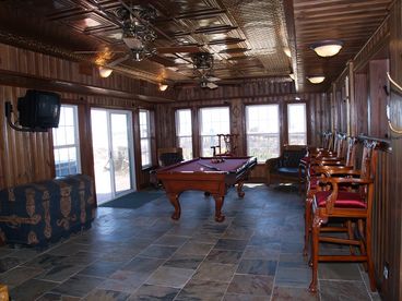 Gameroom with pool table, bar & poker table.