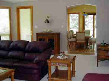 Extra large living room with plenty of seating. Views from a wall of windows. Not shown: TV, large, stone fireplace and spacious entry (foyer).