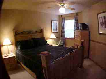 Downstairs bedroom has queen size bed, TV, mirrored closet doors.