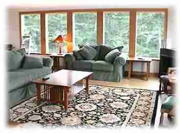 Our living room is lined with windows on the south and west side.  Through the west windows you look out over the west deck and the Pacific.  Through the south windows you look out over Hodgden Creek, into Netarts Bay and into the forest.  The living room is large (almost 400 sq ft), and our open floor plan is perfect for large gatherings (weddings, family reunions, etc.)