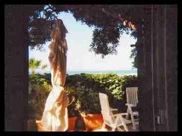 view of the terrace and the sea from the living room of the apartment at the ground floor