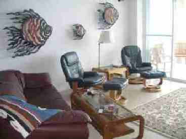 Living room with leather arm chairs with stools and sofa
