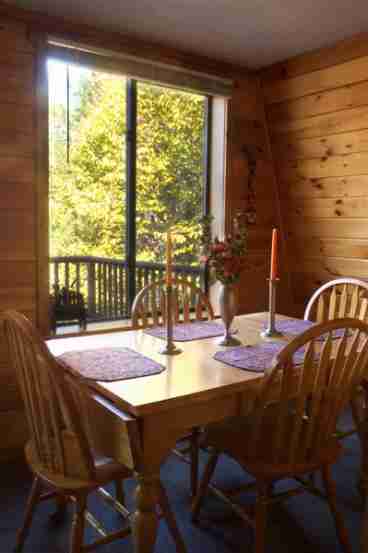 Upper floor dining area overlooks outside deck and lake