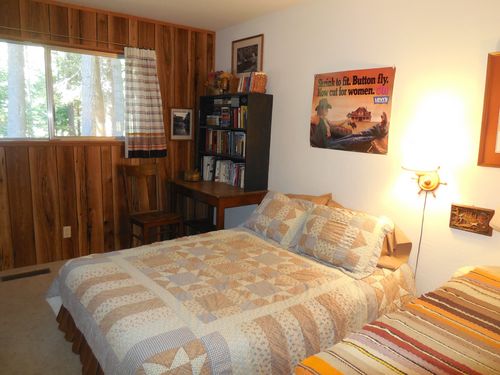 The middle bedroom has a double bed, a desk and many books.