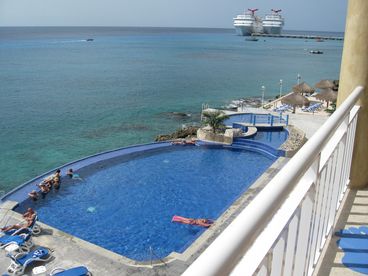 Endless turquoise water seemingly flowing into the sea.  Three tiered swimming pool.