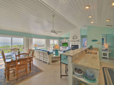 The living-dining-kitchen area is spacious, beautiful, and completely open to the deck and ocean views.