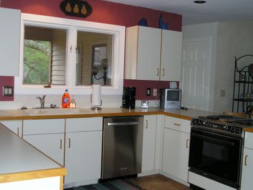 Bright cheery kitchen with breakfast nook,  fully stocked utensils, modern appliances.
