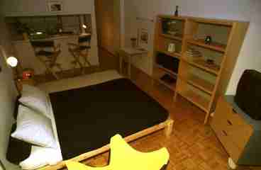 Global view of studio 3A, The kitchen opens up in the living/ sleeping area, a confortable queen size bed in fron of modern libray, a cozy balcony overlooking the browstones of 74th street, lots of closet space and a lot of atmosphere.