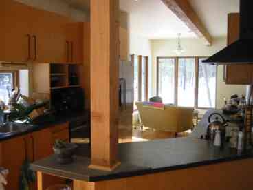 Contemporary, fully equipped kitchen offers view through sunroom. 