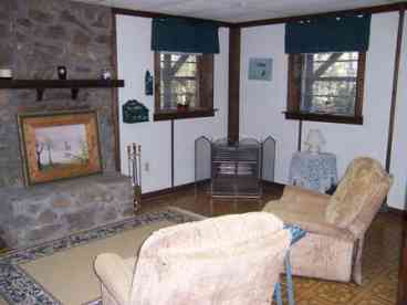 Downstairs living area with satellite tv and woodburning fireplace.