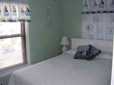 Queen size bed with view of ocean.  Ceiling fan and cable TV.