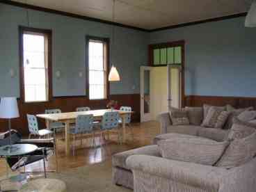 The living and dining room, with views on 3 sides of the room, has a long refectory table for large family meals as well as comfortable seating.